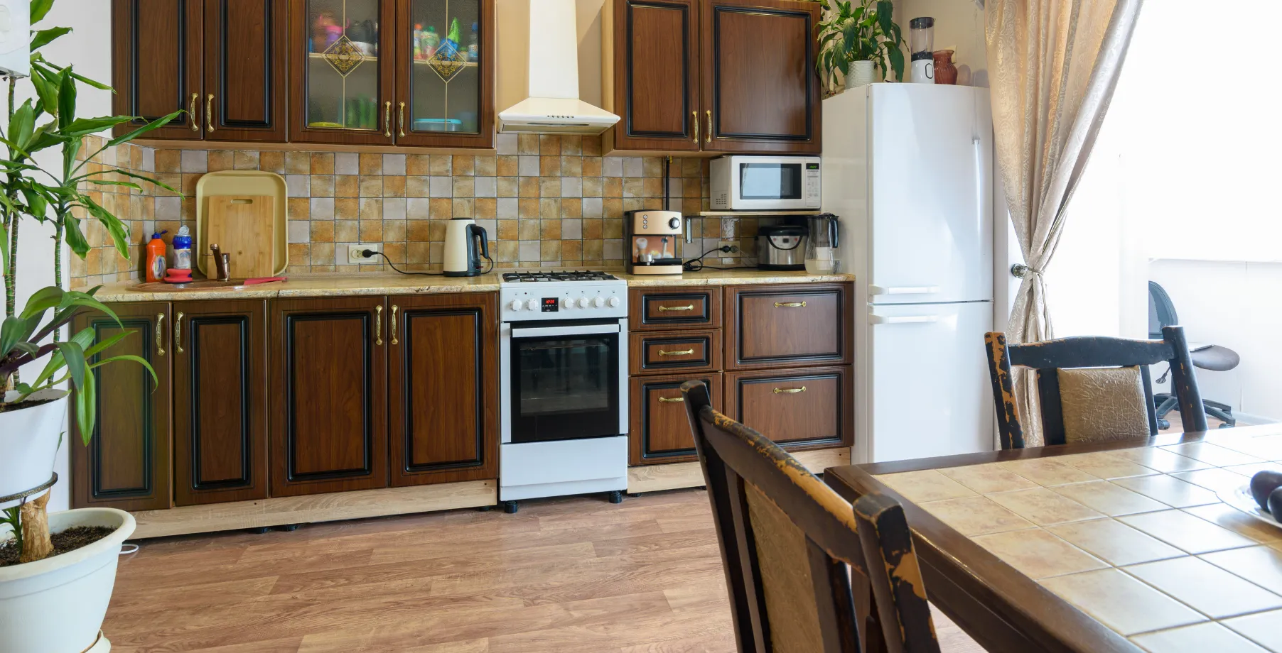 Old kitchen in Los Angeles with dark wood cabinets and outdated appliances before renovation