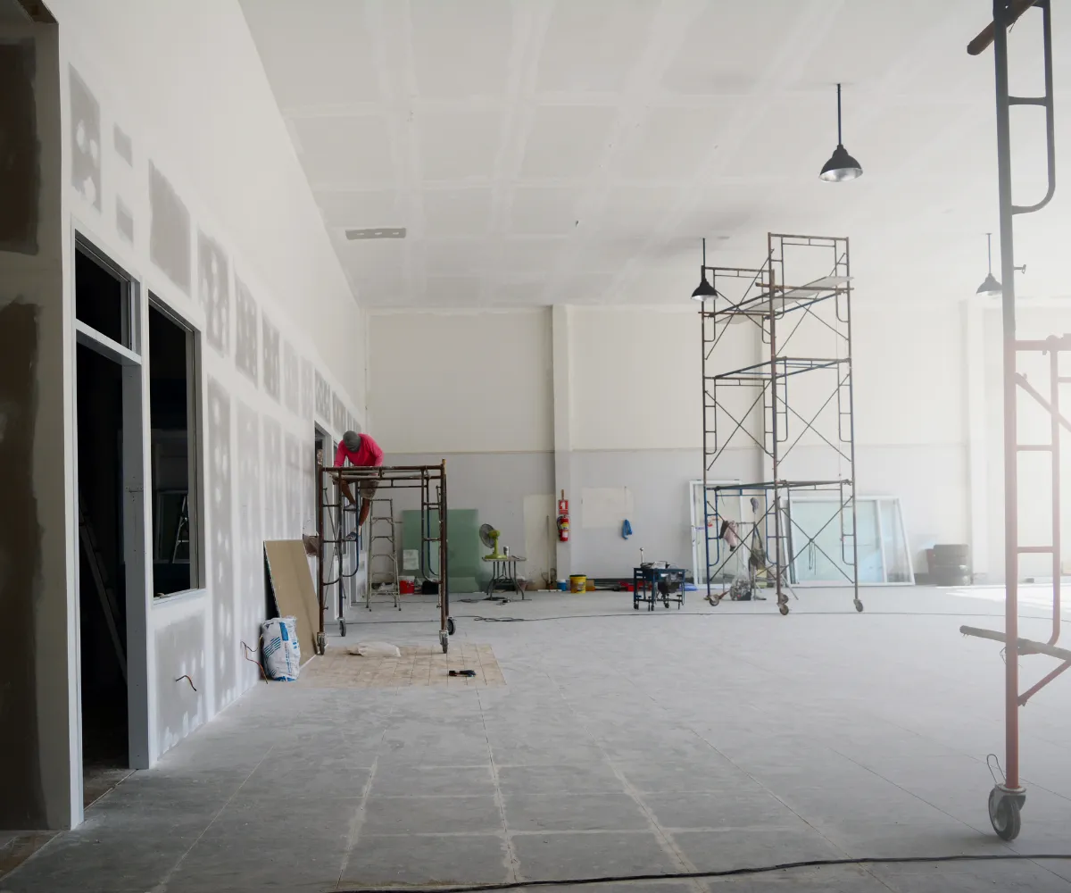 Commercial remodeling project in Los Angeles with large open interior space, drywall installation, and scaffolding during construction phase