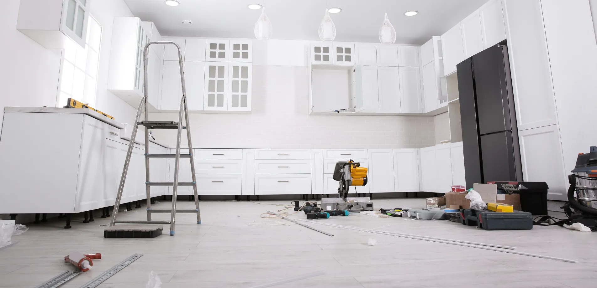 Kitchen remodeling in Los Angeles with white cabinet installation, tools, and modern layout under construction